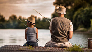 Rear view of a father and son fishing from the pier