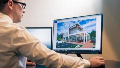 a man sitting at a desk looking at a computer screen